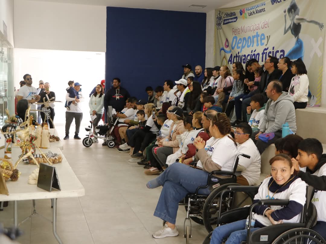 Grupo grande de personas, algunas usuarias de silla de ruedas, reunidas en una actividad comunitaria.