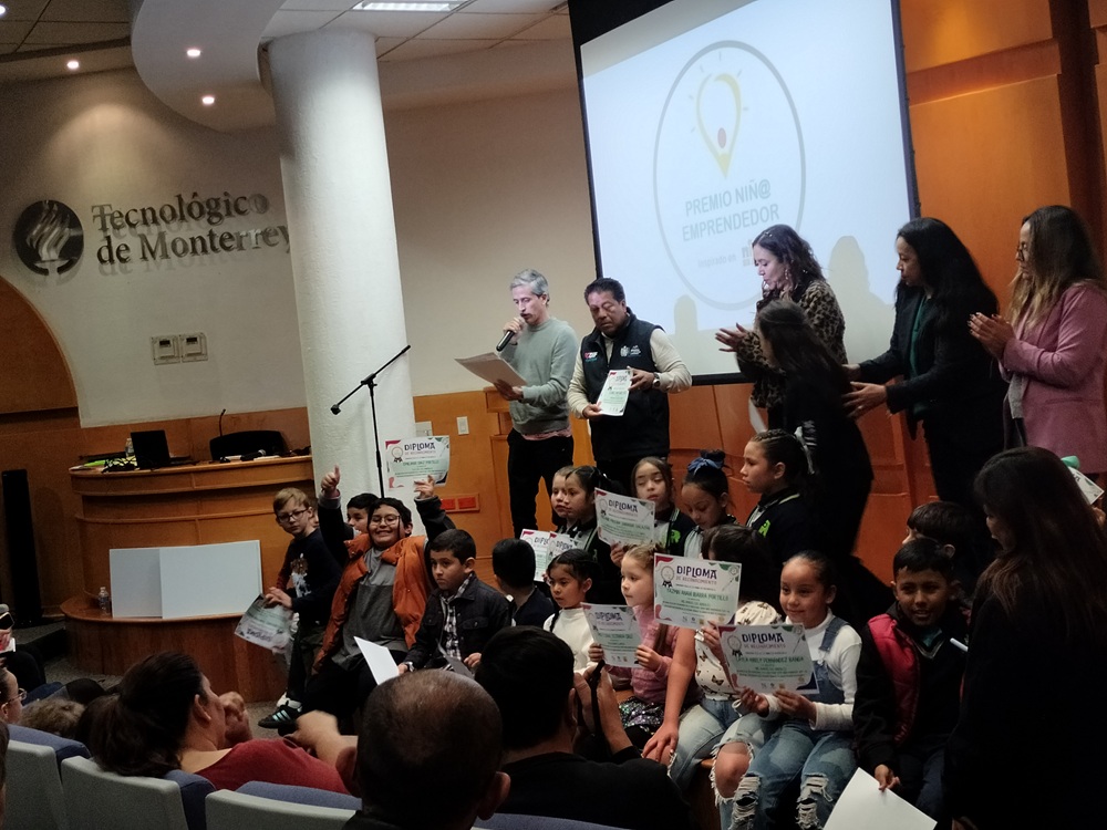 Niñas y niños recibiendo diplomas en un evento en el Tecnológico de Monterrey.