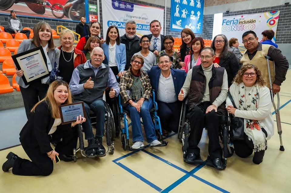 Personas posando juntas con diplomas y reconocimientos.