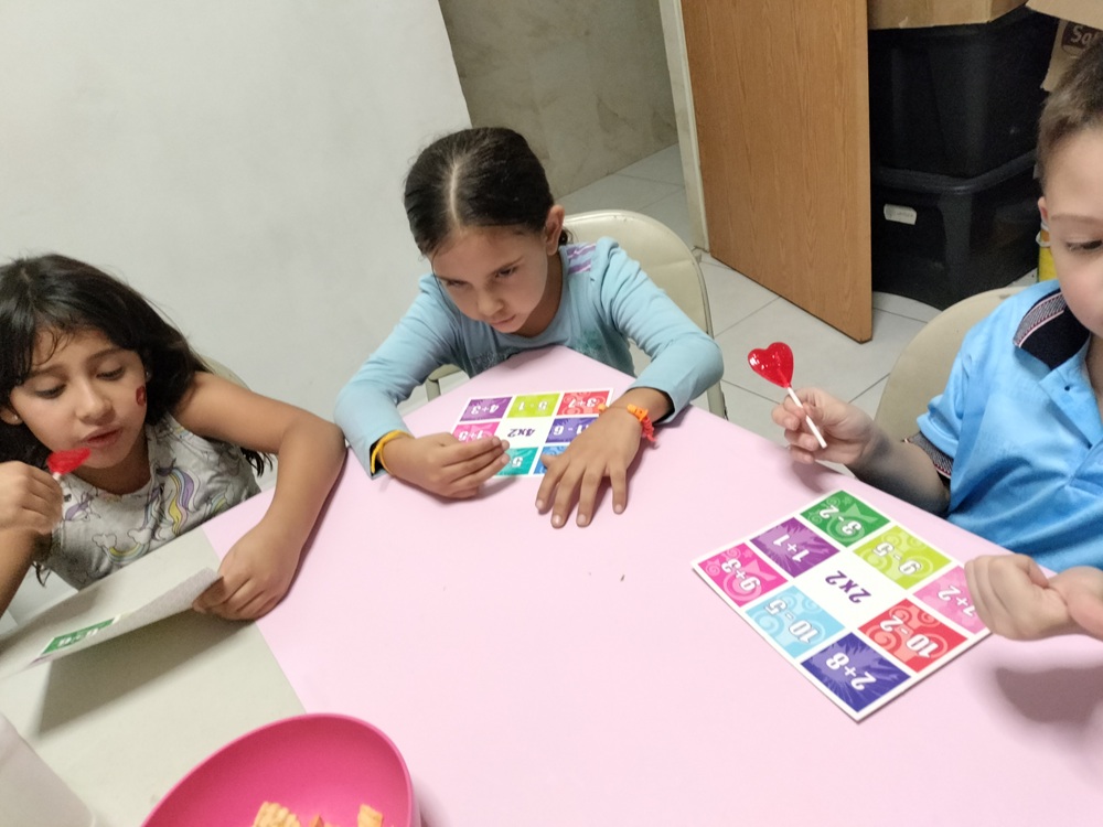 Niñas y niños usando tarjetas numéricas en una actividad.