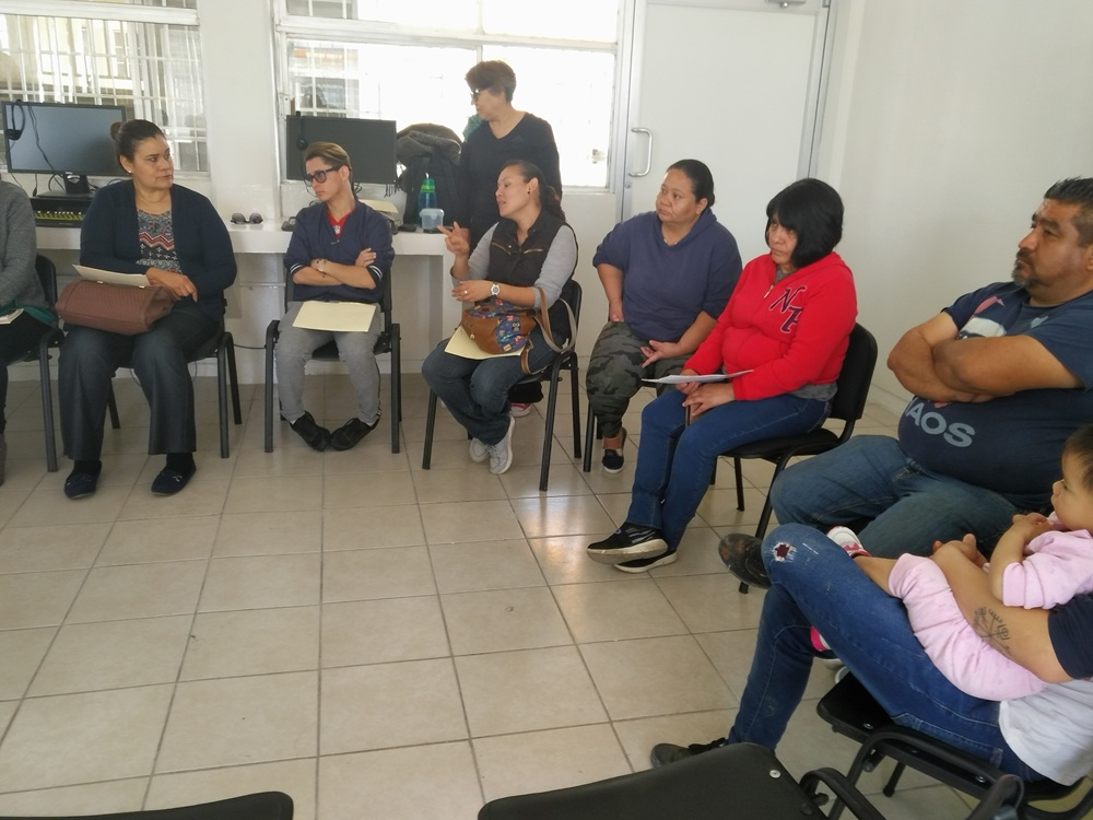 Grupo de personas sentadas en círculo durante una reunión.