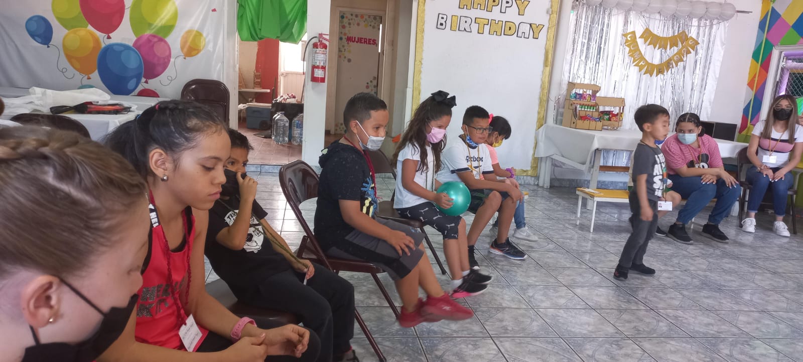 Niñas y niños sentados en círculo realizando una actividad grupal.