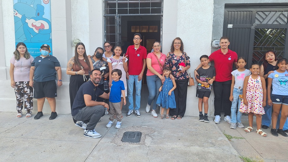 Grupo de personas posando juntas frente a un espacio comunitario.