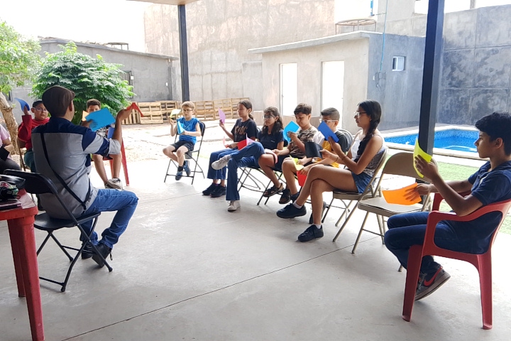 Niños participando en un taller guiados por un facilitador.